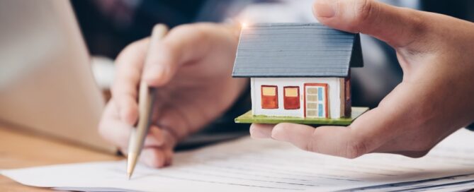 A homeowner applies for a home equity loan with a tiny home in his hand.