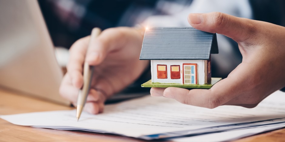 A homeowner applies for a home equity loan with a tiny home in his hand.