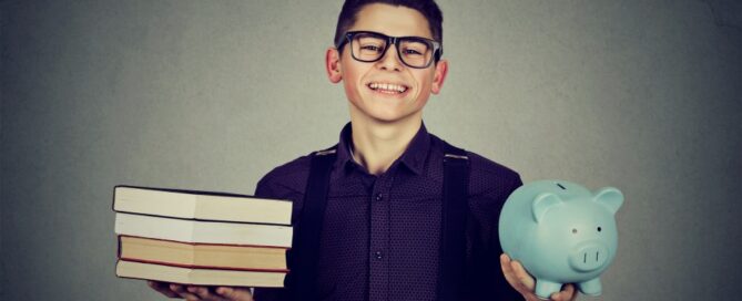 A college student balances his textbooks and a piggy bank.