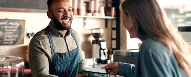 A woman pays for her coffee from her digital wallet on her phone.